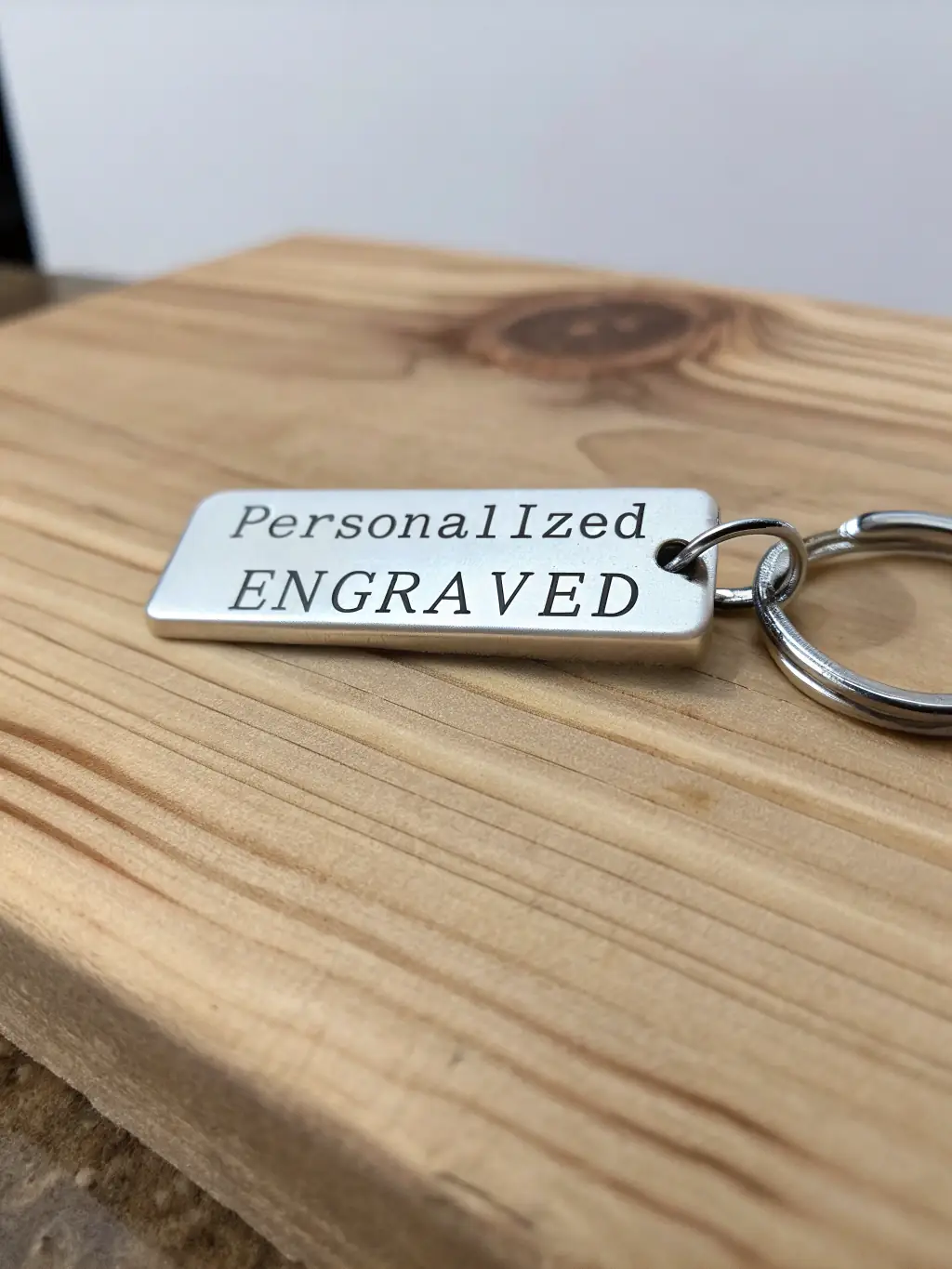 Detailed image of a custom-engraved keychain, highlighting the precision and clarity of the engraving. The keychain features a customer's initials and a significant date.